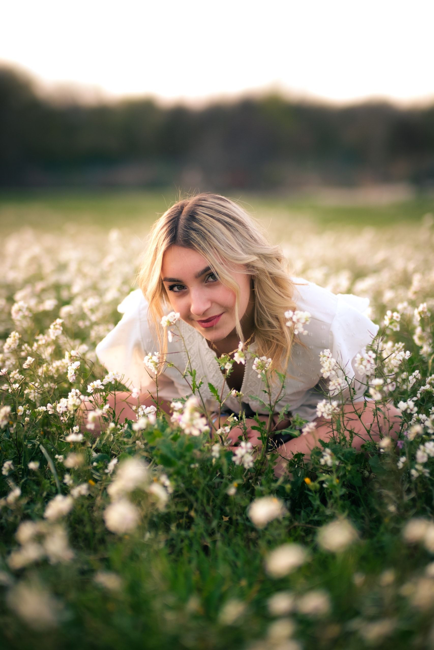Portrait en extérieur : jeune femme dans un champ de fleurs blanches