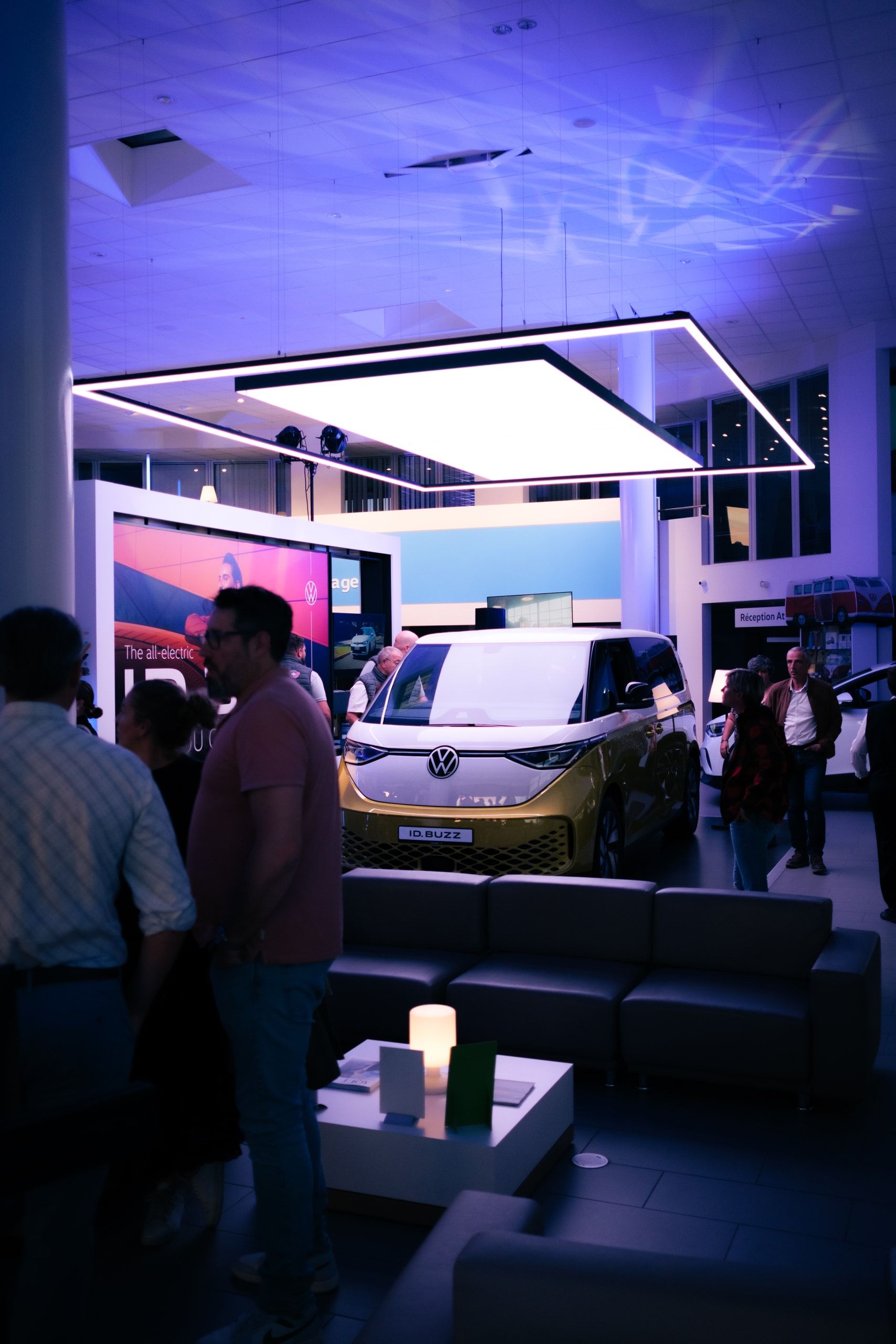 Soirée de lancement automobile dans une concession, sous un éclairage violet